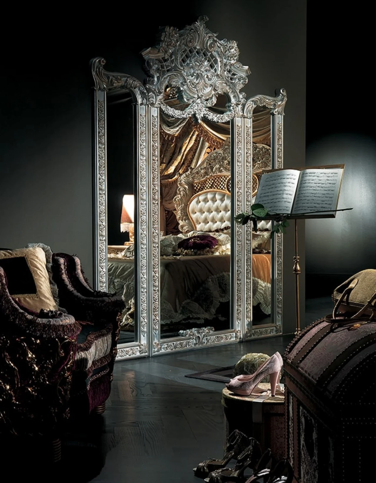 Silver-framed carved mirror in a dark classic bedroom, high end furniture stores in London